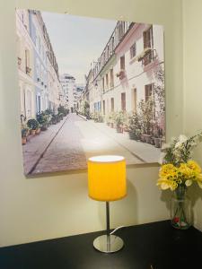 a yellow chair in a room with a picture of a street at Your Cosy and Welcoming HomeStay!! in Ilford