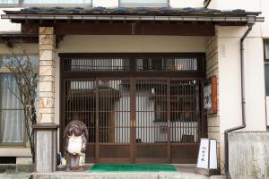 鶴岡市にあるつかさや旅館の犬像を前に置いた扉
