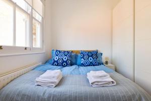 a bedroom with a blue bed with towels on it at The Perfect Portobello Loft in London