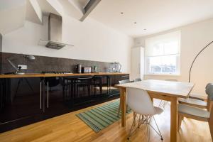 a kitchen with a table and chairs in a room at The Perfect Portobello Loft in London