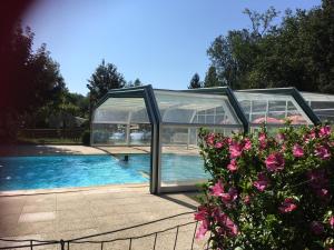 une grande maison en verre avec une piscine dans l'établissement Camping le Relais du Léman, à Messery