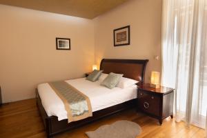 - une chambre avec un lit doté de draps blancs et une table de chevet dans l'établissement Scallop Regent Rooms, à Zadar