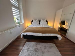 una camera con un grande letto e uno specchio di Europa Apartments nähe Düsseldorf Messe, Airport a Krefeld