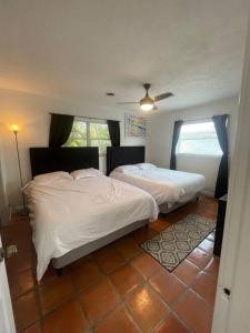 1 dormitorio con 2 camas y ventana en Grotto pool home 5 miles to the beach selfcheck in, en Bradenton