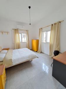 een slaapkamer met een bed, een bureau en 2 ramen bij Fellini talpiot roof dolce vita in Haifa