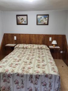 a bed in a bedroom with two pictures on the wall at La Xiana in Taranes