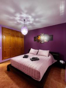 een slaapkamer met paarse muren en een groot bed bij Villa Eclips in Playa Blanca +32 foto's