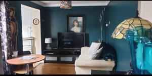 ein Wohnzimmer mit einem Sofa und einem TV in der Unterkunft Art Deco House Dublin Close to City Centre in Ballyfermot