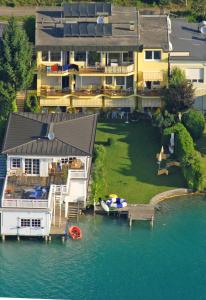 eine Luftansicht eines großen Hauses auf dem Wasser in der Unterkunft Seehaus Jamek in Pörtschach am Wörthersee