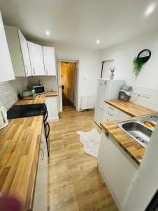 a kitchen with white cabinets and a wooden floor at Mia Property 2 in Bristol