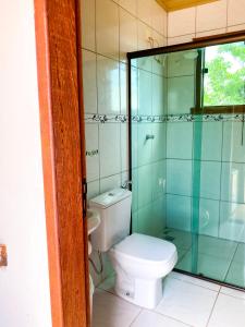 a bathroom with a toilet and a glass shower at Topo do Cipó Ecopousada Vegana in Serra do Cipo
