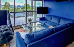 a blue living room with a blue couch and a table at Cozy Home In Brevik With House Sea View in Brevik