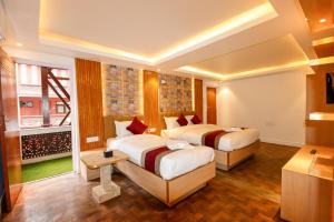 a hotel room with two beds and a window at Hotel Elegant Kathmandu Inn in Kathmandu