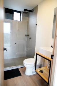 a bathroom with a toilet and a glass shower at Villas Alto Bonito in Sevilla