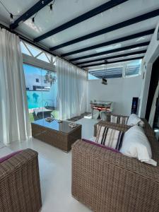 een woonkamer met rieten meubels en een tafel bij Villa Eclips in Playa Blanca