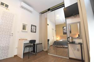 a room with a bed and a desk with a mirror at Il Padrino Rooms in Zadar