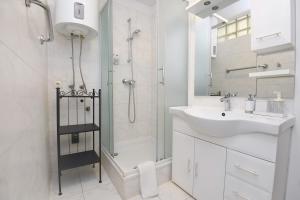 a white bathroom with a sink and a shower at Il Padrino Rooms in Zadar +39 photos