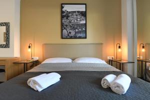 a bedroom with a bed with towels on it at Il Padrino Rooms in Zadar