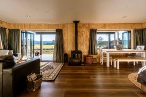 a living room with a couch and a table and a fireplace at Fiery Peak Eco-Retreat in Geraldine