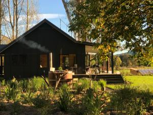 a black house with a picnic table in front of it at Fiery Peak Eco-Retreat in Geraldine