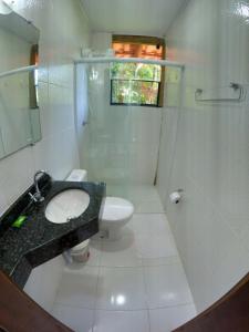 a bathroom with a sink and a shower and a toilet at Chalé e Suite Manacá in Ubatuba