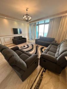 شقه ٣ غرف على البحر فى سبورتنج في الإسكندرية: غرفة معيشة مع أريكتين وأريكة