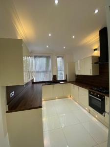 uma grande cozinha com armários brancos e um fogão em Luxury Apartment APT3 em Wolverhampton
