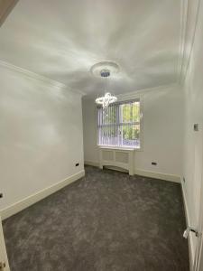 an empty living room with a window and a chandelier at Luxury Apartment APT3 in Wolverhampton