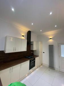 a kitchen with white cabinets and a stove at Luxury Apartment APT3 in Wolverhampton