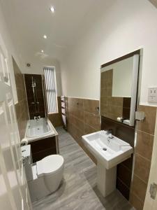 a bathroom with a sink and a toilet and a mirror at Luxury Apartment APT3 in Wolverhampton