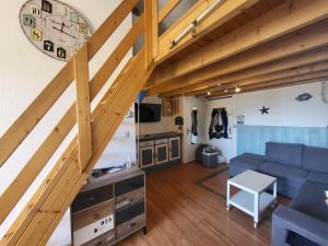 sala de estar con sofá azul y escaleras de madera en Zen, en Gruissan