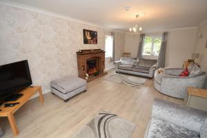 a living room with a couch and a fireplace at Little Hare Lodge - Spacious 2 bedroom attached bungalow in Woodhall Spa