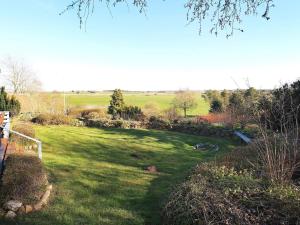 a yard with green grass and trees in the background at 6 person holiday home in Gedsted in Gedsted