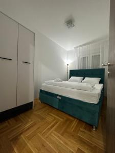 - une chambre avec un grand lit et une tête de lit verte dans l'établissement Port 3, à Belgrade