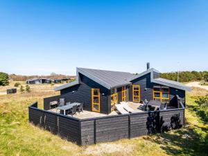 una casa azul en una colina con terraza en 6 person holiday home in Fanø, en Fanø