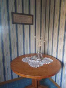 een houten tafel met een vaas met bloemen erop bij Vinegar Hill Airbnb in Bridgetown