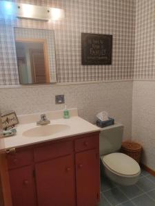 een badkamer met een wastafel, een toilet en een spiegel bij Vinegar Hill Airbnb in Bridgetown