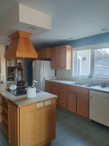 a kitchen with wooden cabinets and a sink and a refrigerator at Vinegar Hill Airbnb in Bridgetown