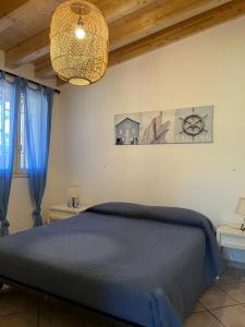 a bedroom with a blue bed and a chandelier at Villa Andrea in Fondachello