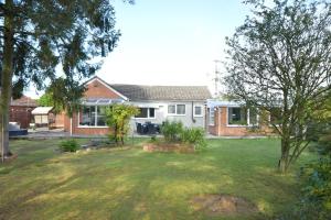 a house with a yard in front of it at Little Hare Lodge - Spacious 2 bedroom attached bungalow in Woodhall Spa