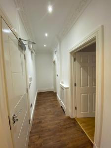 a hallway with a white door and wooden floors at Luxury Apartment with a jacuzzi in Wolverhampton