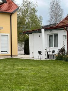 a house with a table and chairs in a yard at Apartman Emily in Nikšić