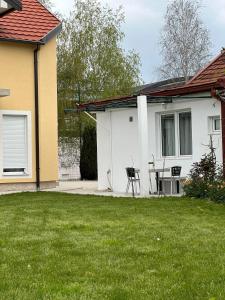a house with a table and chairs in a yard at Apartmani Emily & Jully in Nikšić