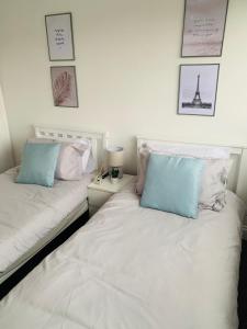 two beds sitting next to each other in a bedroom at Greenshaw 3 Bedroom Terrace in Brentwood