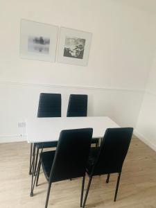 a white table with four chairs in a room at Greenshaw 3 Bedroom Terrace in Brentwood