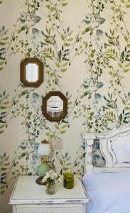 1 dormitorio con pared y papel pintado con motivos florales en Bodega Sibeiro, en Chantada