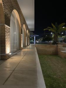 a brick building with an empty sidewalk at night at Kreoli Hotel in Athens