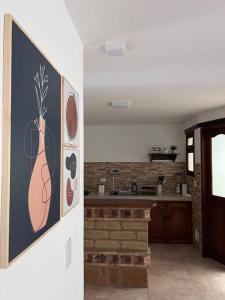een keuken met een schilderij van een vaas op de muur bij Apartamento en Villa de Leyva in Villa de Leyva