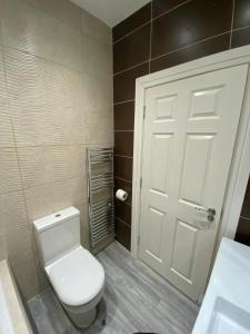 a bathroom with a white toilet and a door at Penthouse APT8 in Wolverhampton