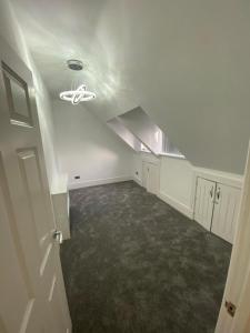 an attic room with white walls and a ceiling at Penthouse APT8 in Wolverhampton